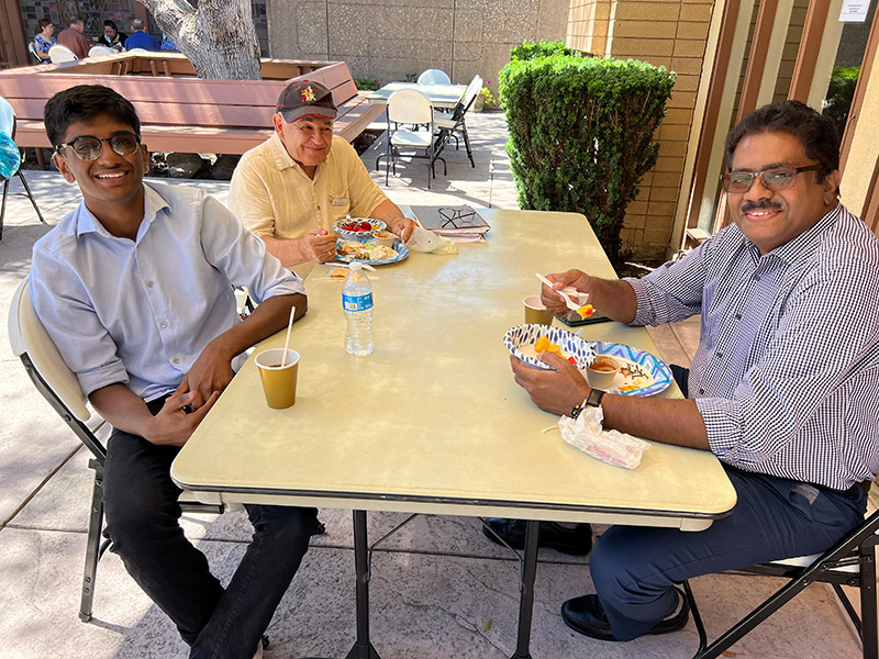 men sitting at a table eating food