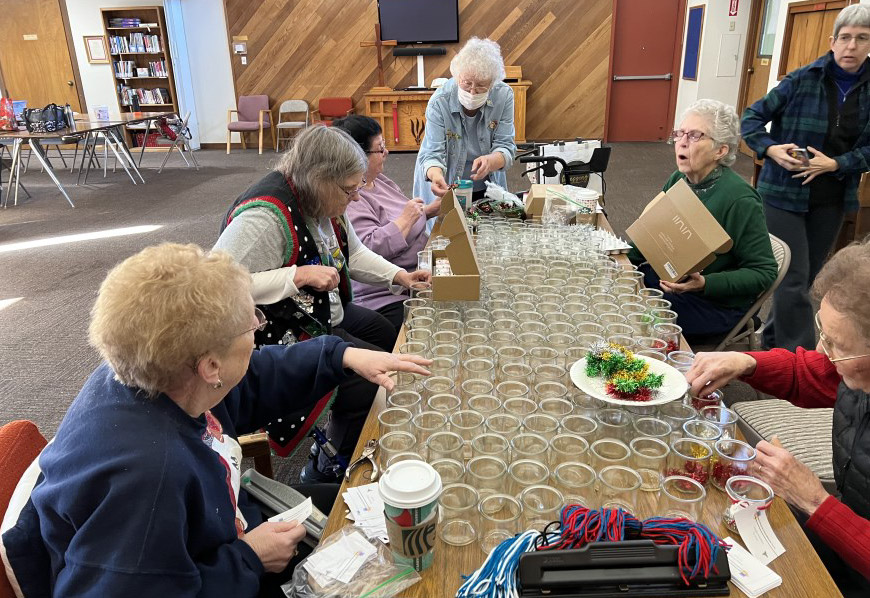 members of the United Women In Faith group work on a craft together