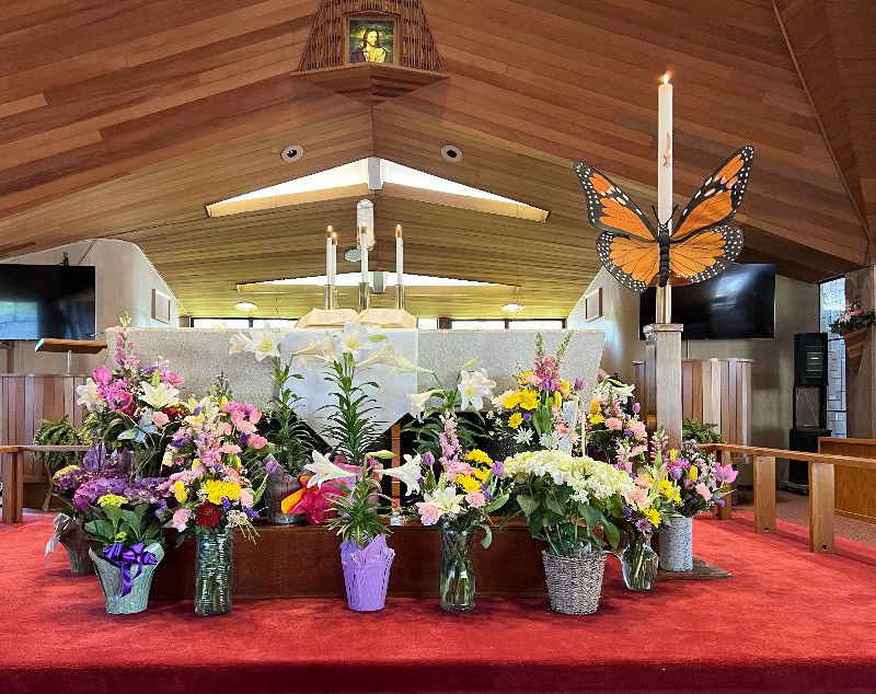 church altar with spring flowers and butterfly decoration