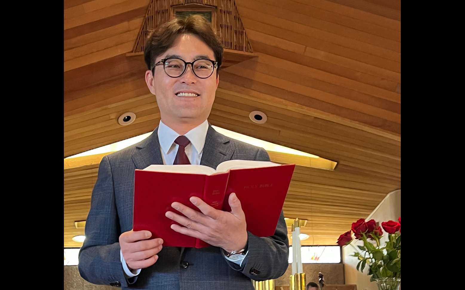 Pastor Jung Min Kim holding a Bible and smiling