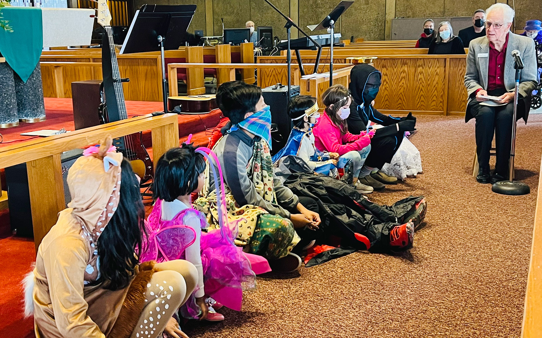 children in costume sitting at the front of the sanctuary during worship
