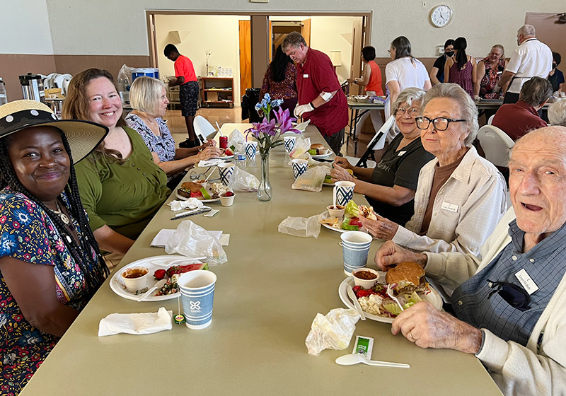 group of adults eating a meal together at the church
