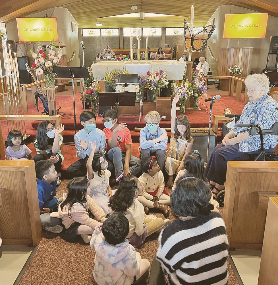 children gather near the altar during worship for children's time